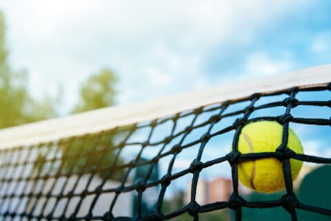 close up photo tennis ball hitting net sport concept